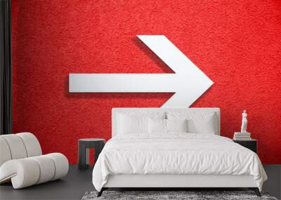 White arrow direction sign over vivid bright red color stucco rough wall as an empty rustic and simple background texture with empty space. Wall mural