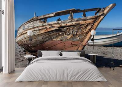 old abandoned wooden boat on the beach, an old shipwreck boat abandoned stand on beach or Shipwrecked off the coast of Cabo de Gata, Almeria, Andalusia, Spain Wall mural