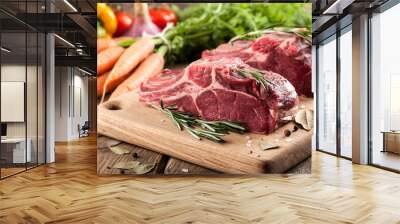 Raw beef meat on cutting board and fresh vegetables Wall mural