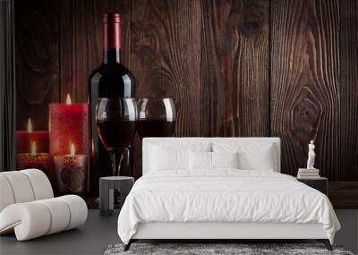 Red wine bottle, two glasses of wine and candles on the dark woo Wall mural