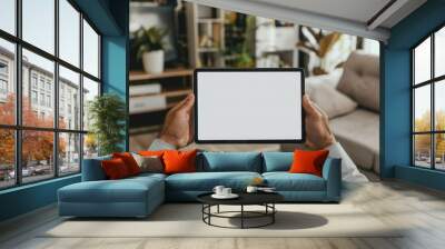 male hands holding a tablet with a blank screen in the living room Wall mural