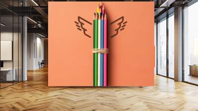 A group of pencils and wings nearby. A symbol of art inspiration and creative ideas Wall mural