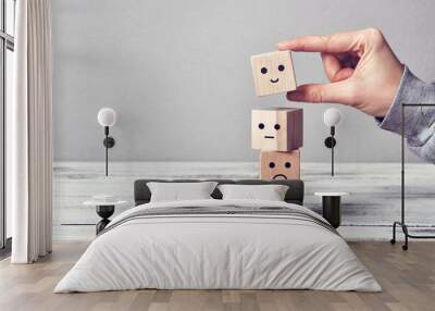 Wooden cubes with drawings of different emotions: sadness, anger, calmness, joy. Choosing joy in life
 Wall mural