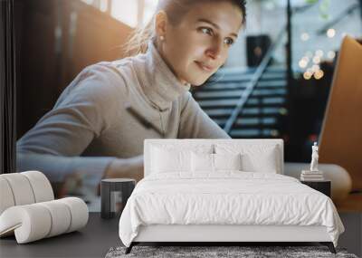 Attractive woman reading good news from business partners on laptop Wall mural