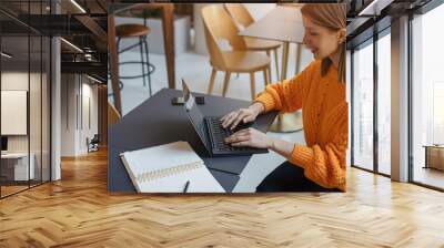 Happy smiling woman working on laptop in co-working place, Female manager having a video call via laptop in coffee shop Wall mural