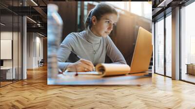 Portrait of young business woman using laptop at library Wall mural