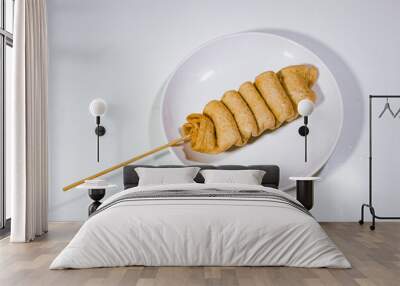 one spoonful of odeng food, served on a plastic plate with a plain white background Wall mural