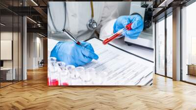 Blood test tubes. Senior female scientist examining blood test tubes at her laboratory dna testing Wall mural