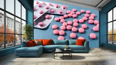 pink pills in a blister on a blue background Wall mural