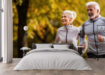 Happy and healthy looking senior couple is joging in the amazing park. Active retirement concept. Stay healthy Wall mural