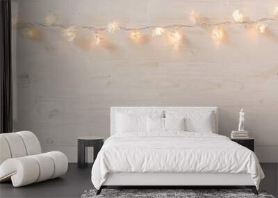 Christmas lights burning  on a white wooden background. Xmas background. Wall mural