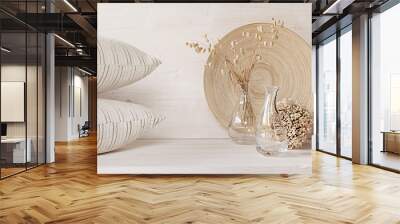 Soft home decor of  glass vase with spikelets and pillows on white wood background. Interior. Wall mural