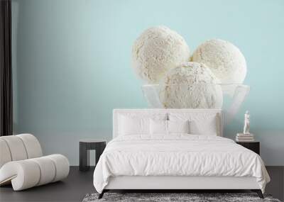 Three creamy ice cream balls in elegant transparent glass bowl on white wood table and pastel mint color wall. Wall mural