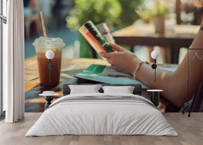 Female reading a magazine and drink ice coffee Wall mural