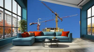 two cranes against the blue sky. construction of a multi-storey building Wall mural