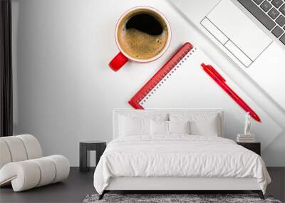 Red coffee cup with red notepad and pen, laptop keyboard on white background Wall mural