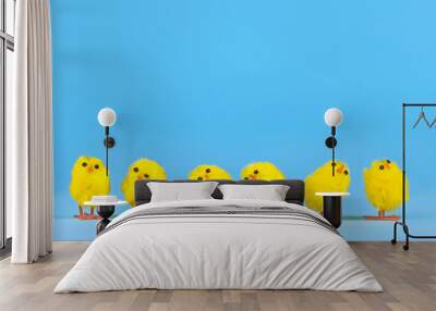 Small decorative easter chickens in a row on blue background Wall mural