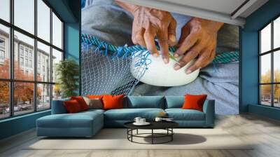 Close up View of Fisherman Fixing Fishing Net, knitting a trawl net, traditional way Wall mural