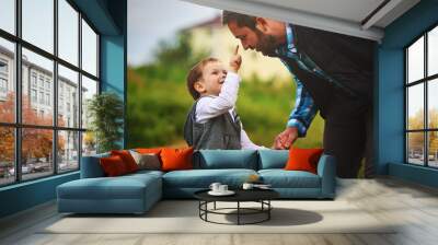 a parent holds the hand of a small child. Father's day Wall mural