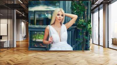 Attractive young blonde girl in town. Beautiful fashionable woman in summer outdoors . Women's beauty and fashion concept Wall mural