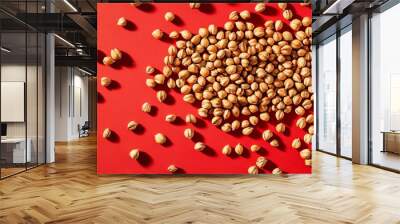 A collection of buckwheat grains on a bold red background, each grain in sharp focus Wall mural