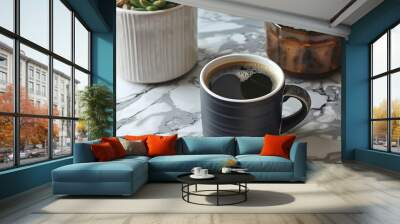 A cup of dark roast coffee in a matte black mug on a marble countertop, with a small pot of succulents nearby Wall mural