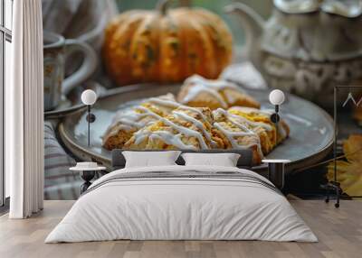 A plate of freshly baked pumpkin scones with a drizzle of maple glaze, served with a cup of tea Wall mural