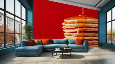 A stack of pancakes drizzled with honey, set against a bold crimson red background for a striking breakfast scene Wall mural