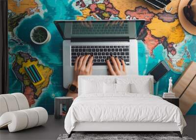 Close up shot of the person's hands typing on a laptop with a minimalist interface and bright travel website icons Wall mural