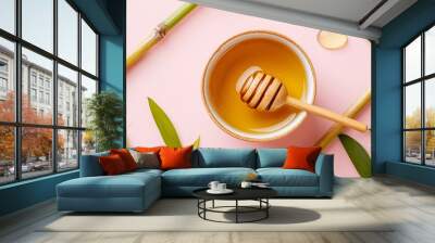 Cup of green tea with honey, isolated on a pastel pink background with decorative tea leaves and bamboo shoots Wall mural