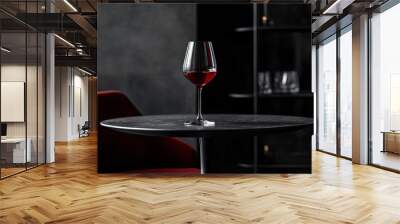 Deep red wine glass on a dark charcoal dining table Wall mural