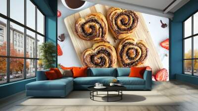 Palmiers with a golden-brown sugar crust, placed on a light wooden board, surrounded by fresh strawberries and a drizzle of chocolate Wall mural