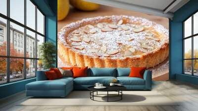 Pear and almond frangipane tart, isolated on a light wooden surface with powdered sugar and sliced almonds as decoration Wall mural