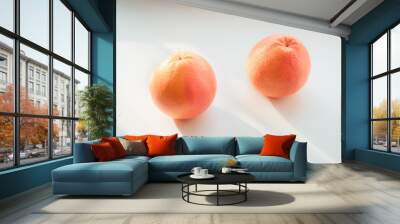 Two grapefruits on a light background in the sun Wall mural