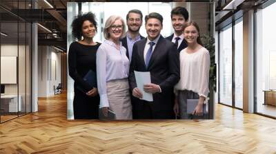 60s and millennial company staff members standing in hallway photo shooting for corporate album. Six successful office workers firm representatives ready for negotiations meeting with client concept Wall mural