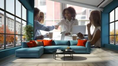 African American team leader shaking hand of businessman at meeting Wall mural