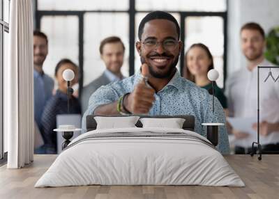 Best ever. Portrait of loyal excited black male client customer demonstrating thumb up sign recommending good product service, happy african employee looking at camera glad to work in company staff Wall mural