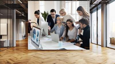 Big group of business people analyzing marketing reports on computers together. Crowded shared office work space. Busy diverse millennial team discussing project, brainstorming at workplaces Wall mural