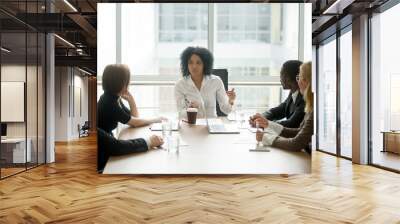 Black female boss leading corporate multiracial team meeting talking to diverse businesspeople, african american woman executive discussing project plan at group multi-ethnic briefing in boardroom Wall mural