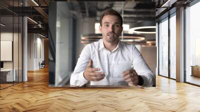 Businessman making video call, looking at camera and talking Wall mural