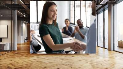 Businessman shake hand of excited Caucasian female employee greeting with achievement or success at office meeting, male boss or CEO handshake happy woman worker congratulate with work promotion Wall mural