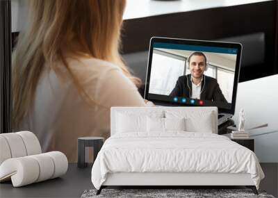 businesswoman making video call to business partner using laptop. close-up rear view of young woman  Wall mural