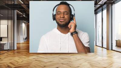 Calm African American man in headphones enjoying favorite music Wall mural