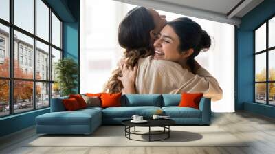 Candid multiracial girls best friends embracing standing indoors Wall mural