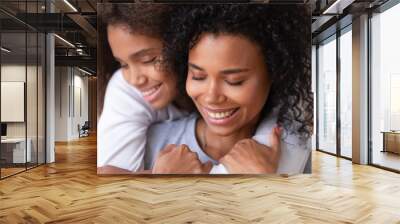 Caring family single mom and african teen daughter embracing cuddling Wall mural