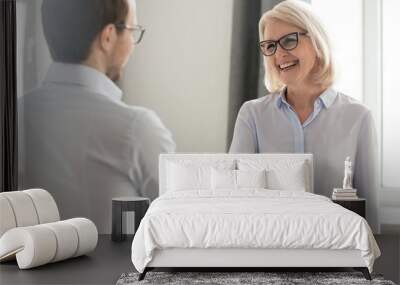 Cheerful middle aged businesswoman handshaking greeting new employee Wall mural