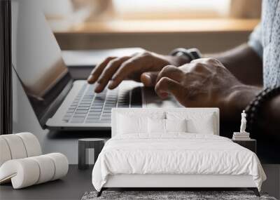 Close up African American male hands typing on laptop keyboard, businessman manager freelancer working on online project, sitting at work desk, using computer, man chatting, browsing apps Wall mural