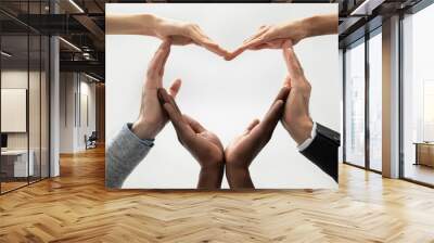 Close up bottom view concept of diverse business people join hands forming heart. Show unity and support, protection of business. Multiracial colleagues involved in team building activity for charity. Wall mural