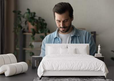 Close up focused man looking at phone screen, standing at home, browsing mobile device apps, reading news, chatting or shopping online, searching information in internet, holding smartphone Wall mural