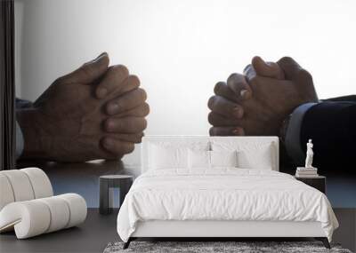 Close up of businessmen sit at table with hands clenched Wall mural